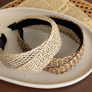 Detail of French Bohemian woven straw headbands in beige and brown with crisscross texture