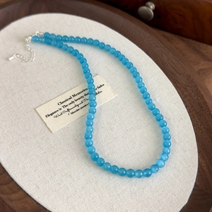 Detailed macro of sky blue cat eye stone beaded necklace with adjustable silver lobster clasp