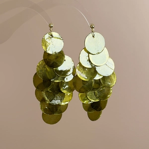 Detailed view of layered mint green shell discs and golden metal hooks on a display stand