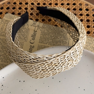 Close-up of bohemian woven straw headband texture on a white plate background