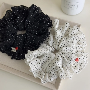 Close-up of polka dot scrunchies with ruffles, handmade labels and red heart buttons