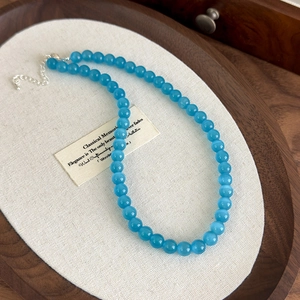 Detailed view of blue cat-eye beads necklace with adjustable silver metal clasp