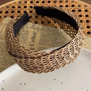 Close-up of bohemian woven straw headband with cross texture on vintage paper background