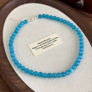 Close-up of blue cat eye stone beaded necklace with silver lobster clasp and extender