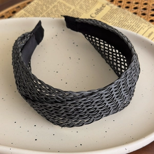 Detailed texture of black straw woven headband with comfortable inner lining and vintage style