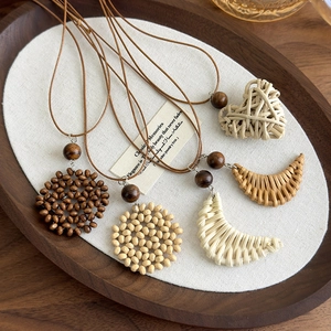 Bohemian style five-piece necklace set with heart and moon pendants on a wooden tray