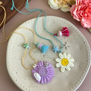 Détails de pendentifs fleurs tissés à la main avec coquillages et étoiles de mer