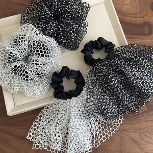 Detail of silver and black sequin mesh scrunchies with elegant long tail design
