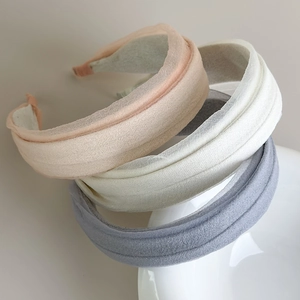 Detail showing the soft pleated fabric texture and sponge padding on wide headbands