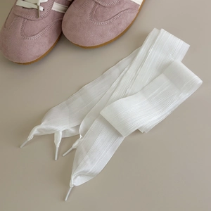 Detail showing semi-transparent white organza shoelaces with delicate wavy texture