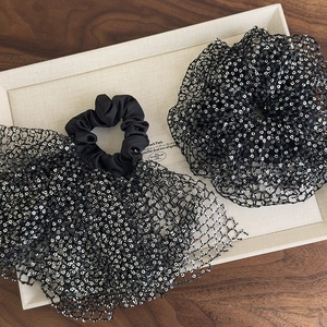 Detail of black sequined tulle scrunchie set with large bow in a vintage French style