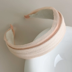 Detail view of champagne padded chiffon headband with soft sponge texture and elegant design