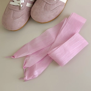 Detailed macro of light pink organza ribbon shoelaces with elegant vertical texture