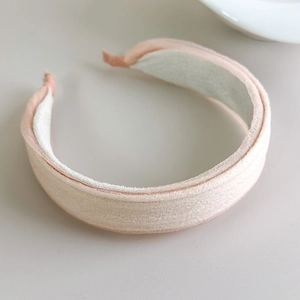 Close-up of thick apricot pink fabric headband with soft texture and padded volume effect
