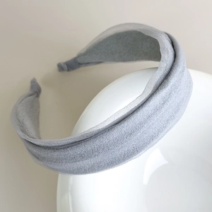 Close-up of light grey wide headband with textured layered fabric on white bowl