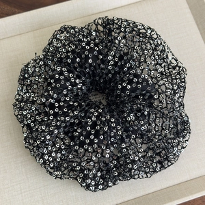 Close-up of black mesh scrunchie with sparkling silver sequins and lace edge detail