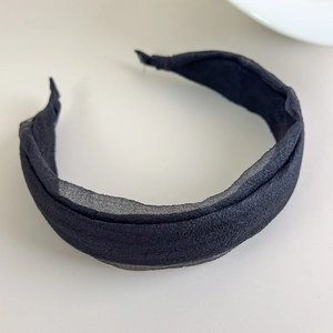 Detail view of the layered black chiffon fabric folds on the elegant wide-brim headband