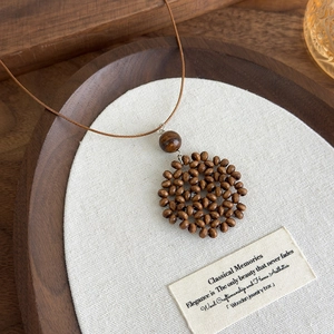 Detail of bohemian heart moon woven wooden bead necklace with intricate textures