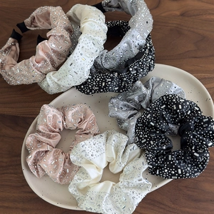 Dettaglio del set di elastici e cerchietti in raso con strass in quattro colori classici