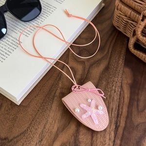 Détail d'un clip à lunettes étoile rose avec paillettes, perles et nœud décoratif