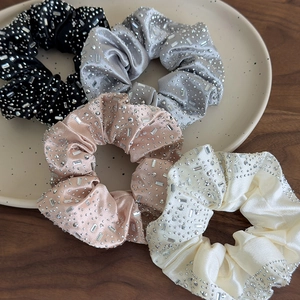 Dettaglio di quattro elastici in raso con strass in nero, argento, rosa e beige
