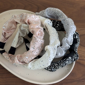 Dettaglio del cerchietto in raso di lusso con decorazioni in strass e cristalli lucidi