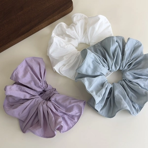 Detail of large oversized scrunchies in purple, white and blue with soft fabric texture