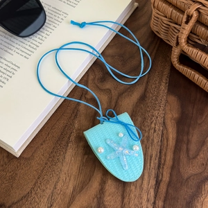 Détail du pendentif étoile de mer bleu clair avec perles sur fond en bois artistique