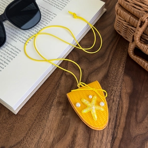 Gros plan d'un pendentif étoile de mer jaune tressé avec perles sur un bureau en bois