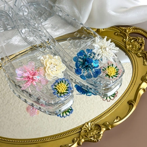 Close-up of colorful handcrafted beaded flower charms on transparent jelly sandals
