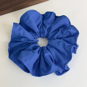 Macro shot of large royal blue ruffled scrunchie with textured fabric for high ponytails