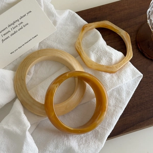 Ensemble de trois bracelets en résine ambrée aux motifs marbrés et formes géométriques