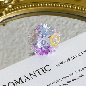 Detail of handmade beaded flower charm with colorful resin petals for DIY footwear