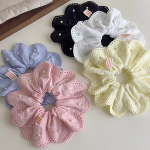 Détail de chouchous en dentelle florale avec perles blanches et étiquettes faites à la main