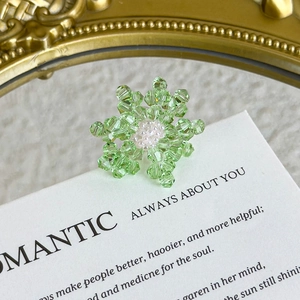 Detail of handmade green crystal flower shoe charm with delicate pearl bead core