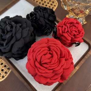 Nahaufnahme von roten und schwarzen Rosen-Haarklammern mit Satin-Blütenblättern