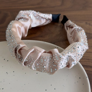 Dettaglio del cerchietto in raso champagne con strass scintillanti e cristalli