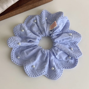 Vue détaillée du chouchou en dentelle lilas avec perles brodées et étiquette de marque
