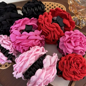 Detailaufnahme großer Rosen-Haarklammern aus Stoff in Rot, Pink und Schwarz