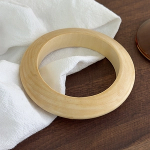 Vue détaillée de la texture du bois naturel sur un bracelet jonc rond rétro minimaliste