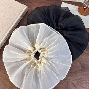 Détail rapproché de grands chouchous en organza à volants en noir et beige élégant