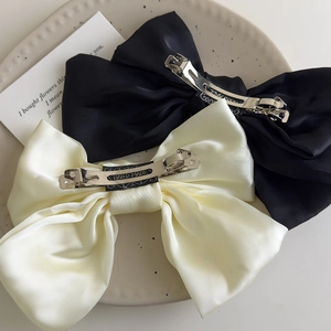 Detail of elegant satin bow hair clips with handmade metal spring clip texture and finish