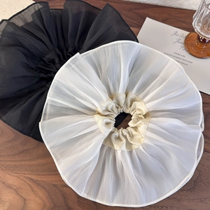 Détail de chouchous froncés surdimensionnés en organza noir et crème sur bois