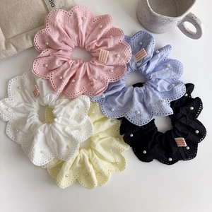 Détail de cinq chouchous en dentelle assortis avec perles blanches et étiquettes faites main