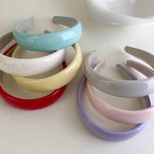 Close-up of colorful glossy patent leather headbands with soft velvet non-slip lining