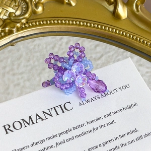 Close-up of handmade purple crystal flower shoe charms with elegant beaded petals