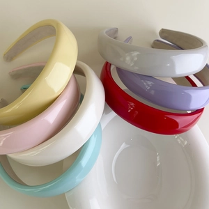 Close-up of colorful patent leather padded headbands with shiny finish and non-slip lining