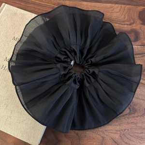 Vue détaillée du chouchou plissé noir surdimensionné montrant les couches de tissu