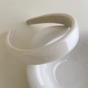 Detailed close-up of cream padded sponge headband with premium matte faux leather texture