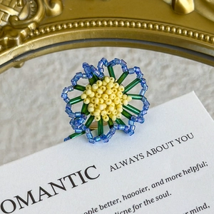 Detailed view of handmade beaded flower charms with blue petals for DIY jelly shoes